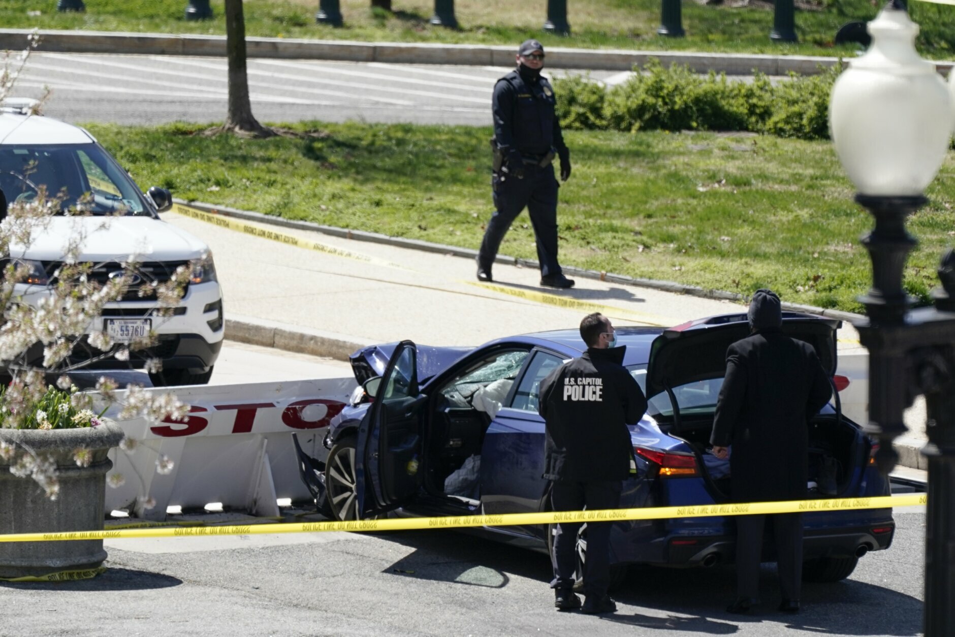 U.S. Capitol Police officers stand near a car that crashed into a barrier on Capitol Hill in Washington, Friday, April 2, 2021. (AP Photo/J. Scott Applewhite)