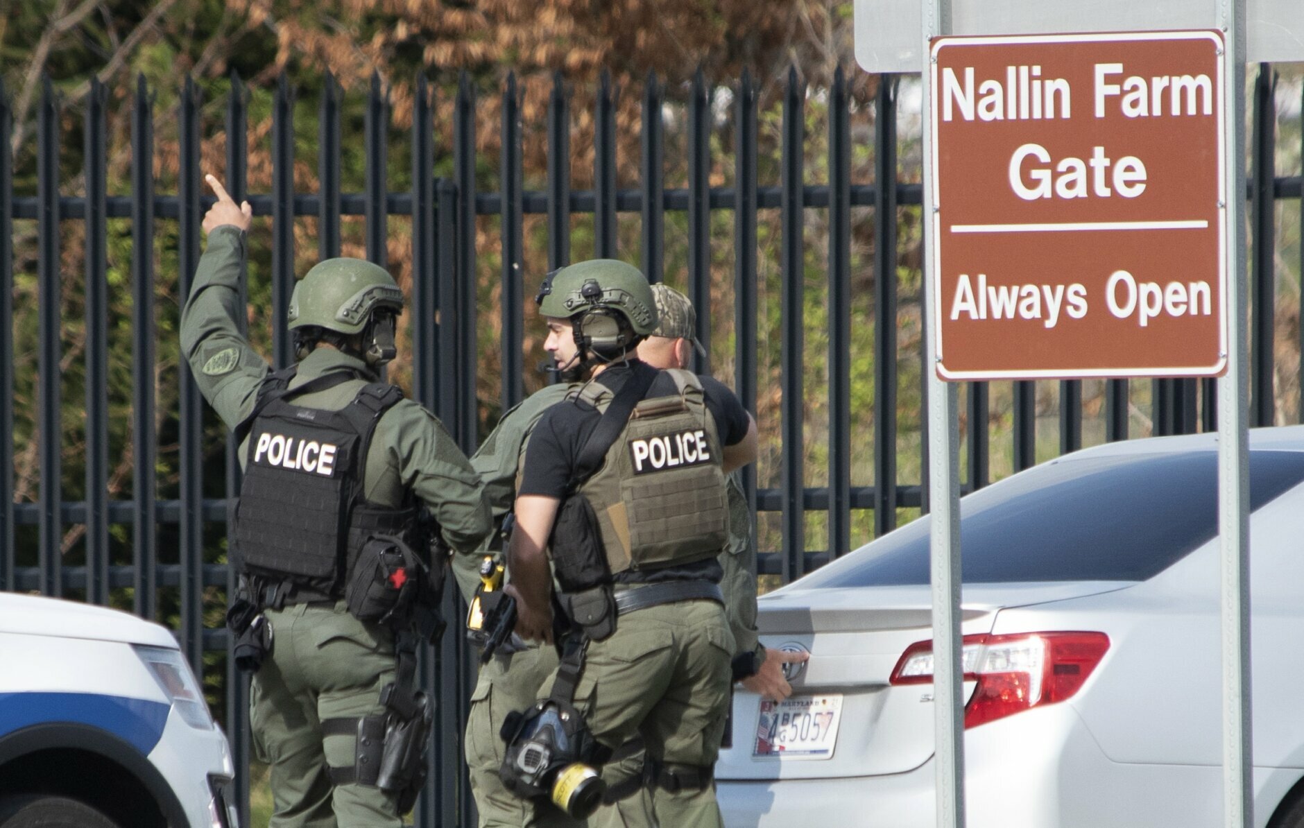 Members of the Frederick Police Department Special Response Team prepare to enter Fort Detrick at the Nallin Farm Gate in a convoy of vans and sedans following a shooting in Riverside Tech Park, near the Royal Farms on Monocacy Boulevard, Tuesday, April 6, 2021, in northeast Frederick, Md. Authorities say a Navy medic shot and critically wounded two people at a Maryland business park before fleeing to the Fort Detrick Army base, where he was shot and killed. (Graham Cullen/The Frederick News-Post via AP)