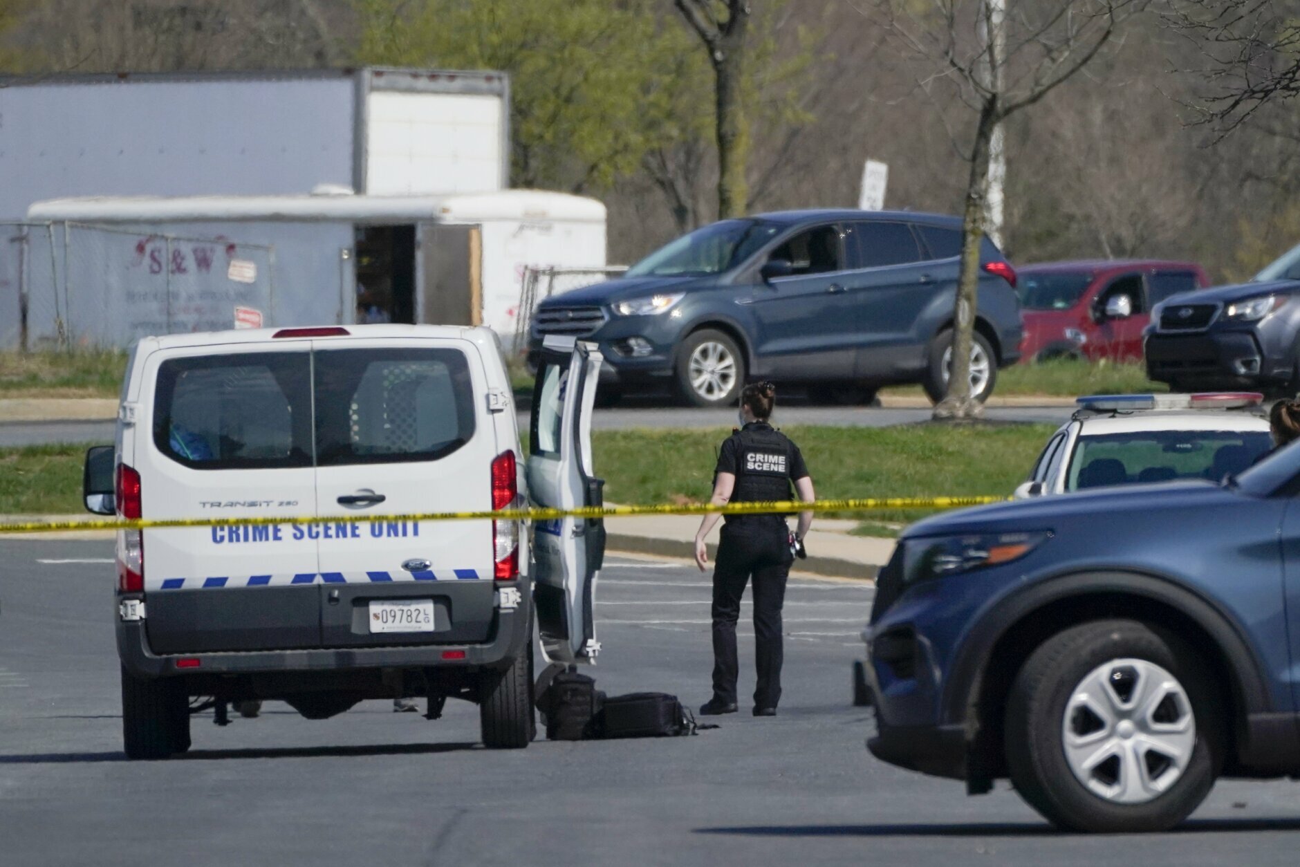 A crime scene technician stands near the scene of a shooting at a business park in Frederick, Md., Tuesday, April 6, 2021. (AP Photo/Julio Cortez)