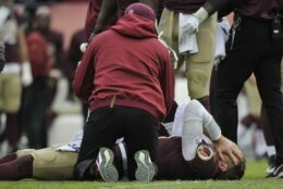 FILE - Washington Redskins quarterback Alex Smith, bottom, reacts after an injury during the second half of an NFL football game against the Houston Texans in Landover, Md., in this Sunday, Nov. 18, 2018, file photo. Smith announced his retirement Monday, April 19, 2021, on Instagram, saying he still has plenty of snaps left him just shy of his 37th birthday but is calling it quits to enjoy time with his family. Smith earned AP Comeback Player of the Year honors for getting back on the field last season, two years removed from his gruesome injury that required 17 surgeries to repair. (AP Photo/Mark Tenally, File)