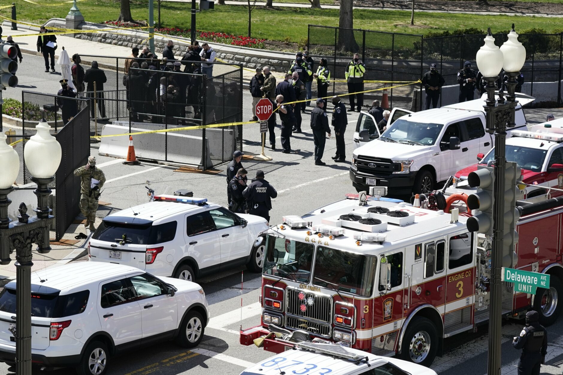 Police and fire officials stand near a car that crashed into a barrier on Capitol Hill in Washington, Friday, April 2, 2021. (AP Photo/J. Scott Applewhite)