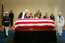 <p>SIMI VALLEY, UNITED STATES: Former US First Lady Nancy Reagan(C) is embraced by Reverend Robert Wenning as they stand by the casket containing the remains of former US President Ronald Reagan at the Ronald Reagan Presidential Library 07 June, 2004 in Simi Valley, California. Reagan, 82, wearing a black suit, touched the flag-draped coffin of her husband of 52 years and briefly laid her head on it at a short service held after his body arrived at his presidential library where he will lie in repose for two days ahead of his state funeral 11 June. AFP PHOTO/POOL/ Rick Bowmer (Photo credit should read POOL/AFP via Getty Images)</p>
