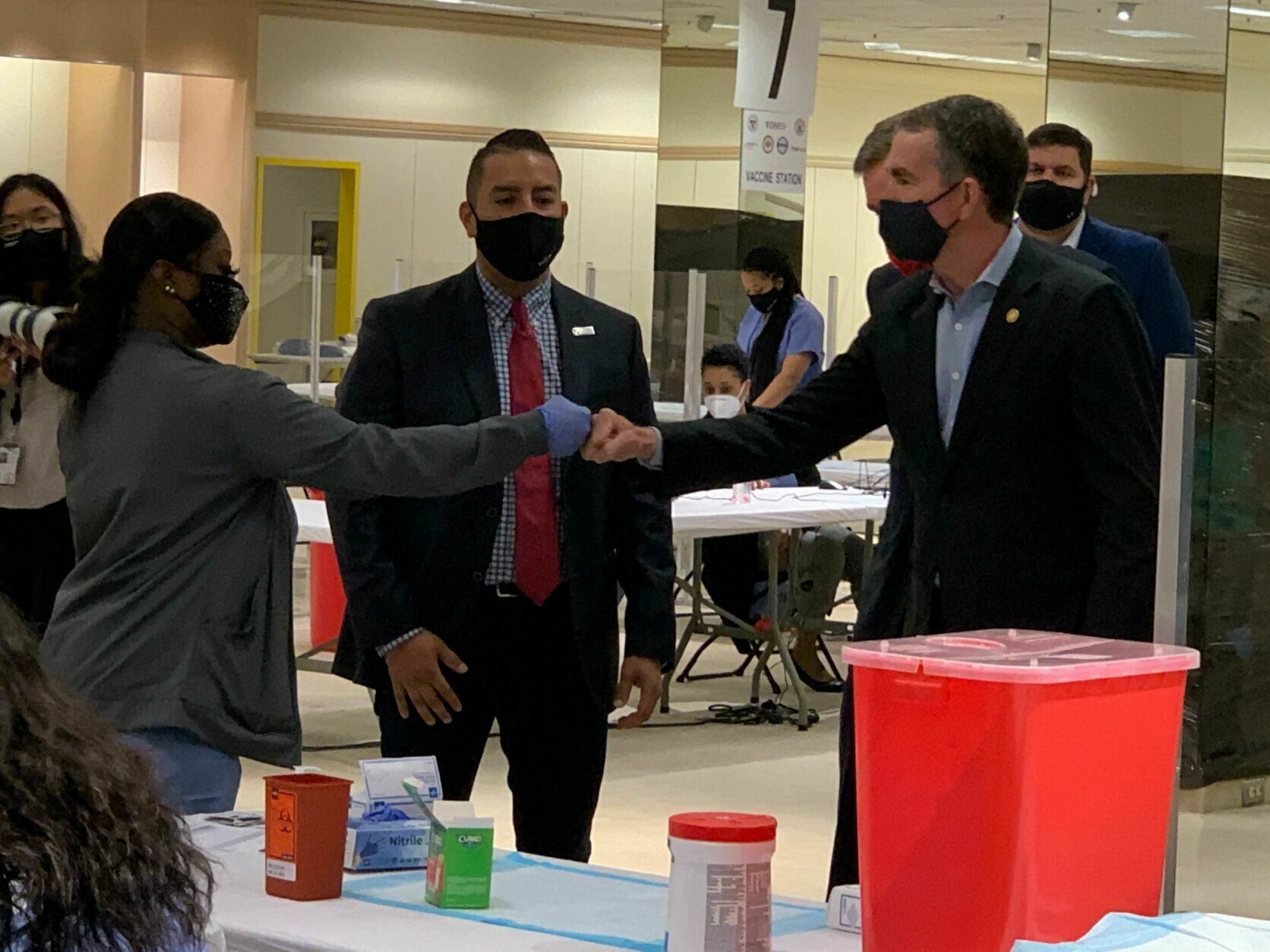 <p>Virginia Gov. Ralph Northam fist-bumps a nurse at the vaccination site during a tour on Monday. Northam was joined by Sen. Mark Warner.</p>
