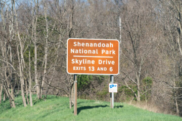 Shenandoah National Park and Skyline Drive exit brown information and direction sign on road highway in Markham Virginia in spring with trees
