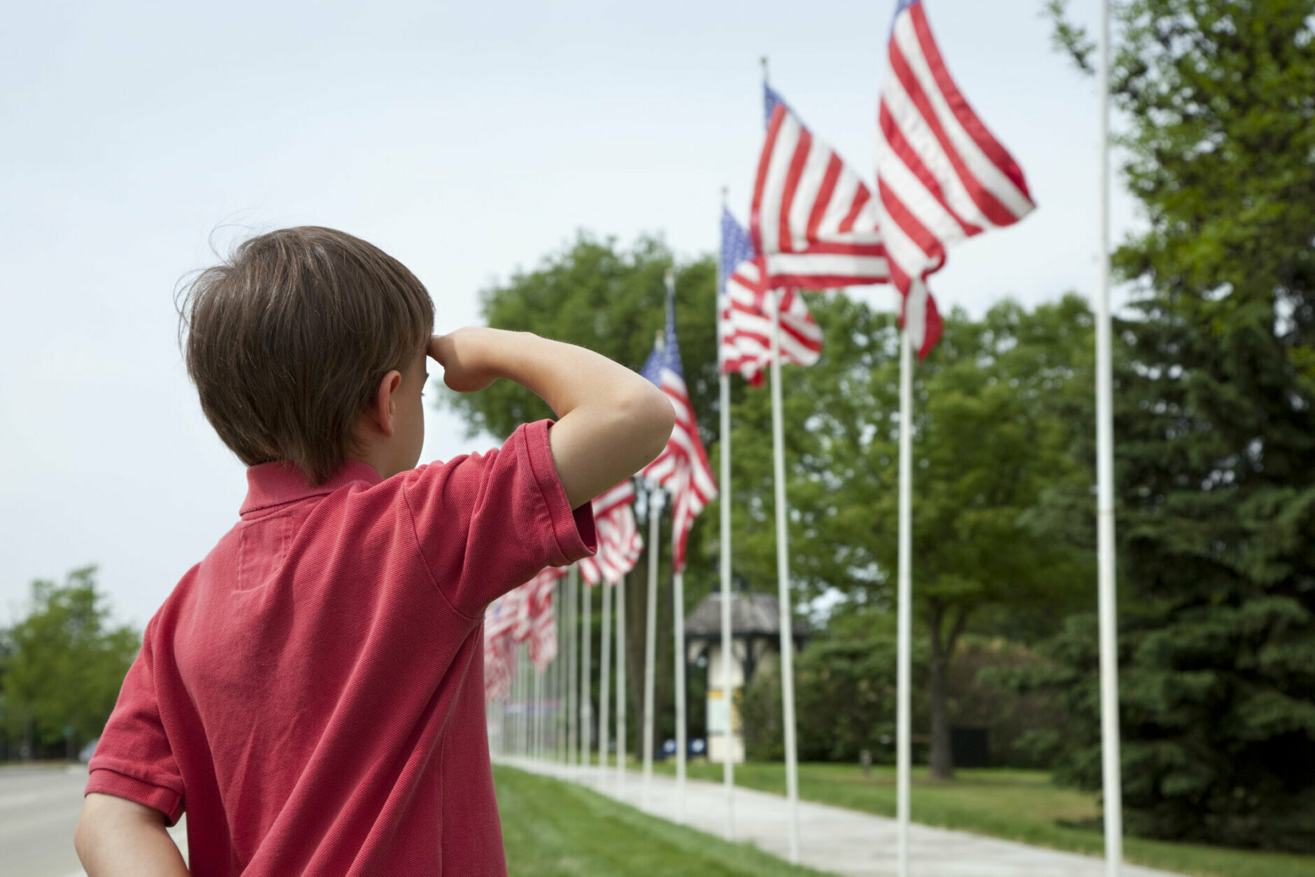 Young boy salutes flags of Memorial Day display in a small townOther images: