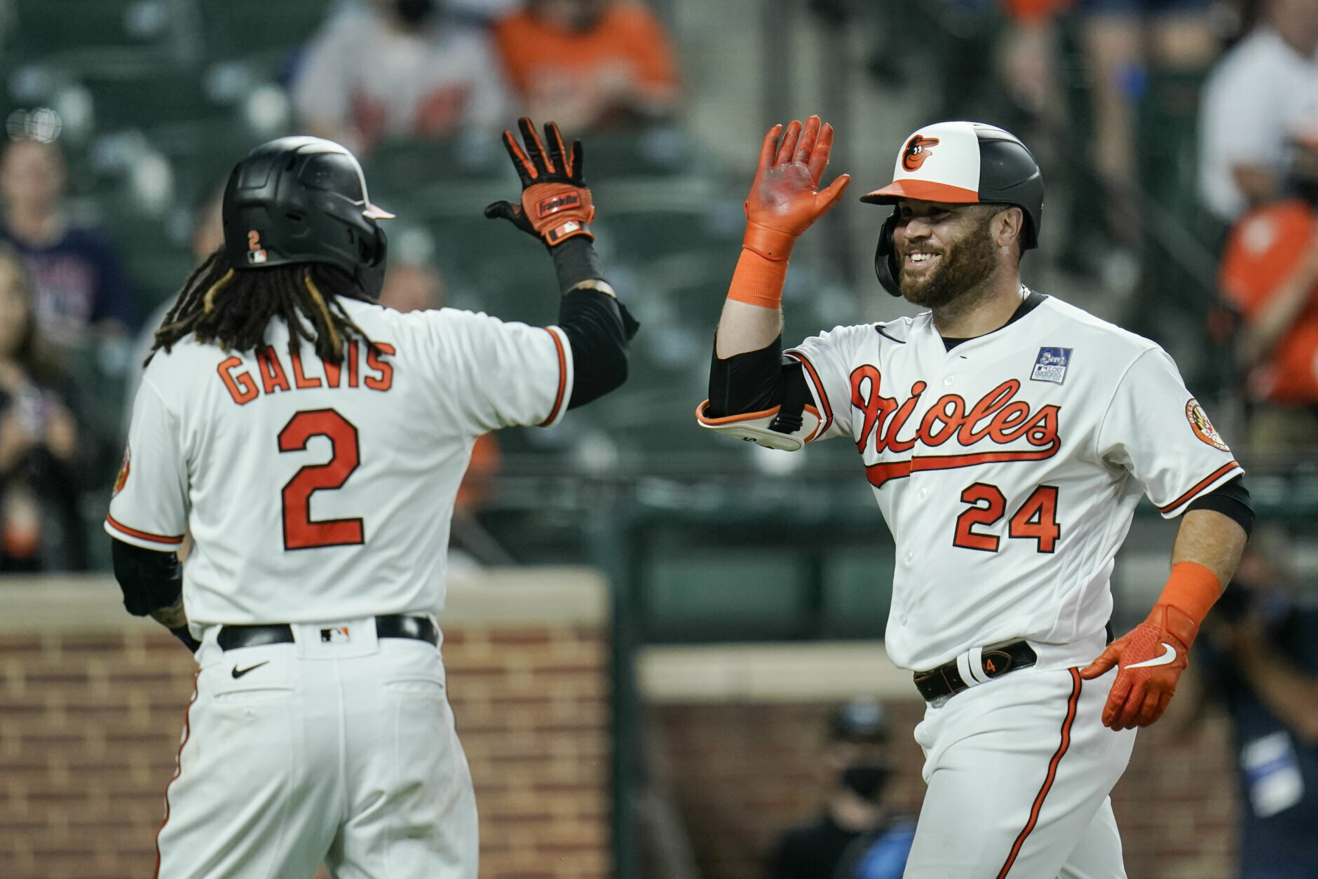 Baltimore Orioles' DJ Stewart (24) is greeted near home plate by Freddy Galvis (2) after Stewart scored both of them on a two-run home run against Minnesota Twins starting pitcher Randy Dobnak during the fifth inning of a baseball game, Wednesday, June 2, 2021, in Baltimore. (AP Photo/Julio Cortez)