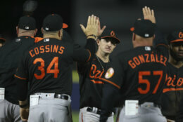 Baltimore Orioles' Austin Hays, center, high-fives Tim Cossins (34) and Fredi Gonzalez (57) after a baseball game against the Toronto Blue Jays in Buffalo, N.Y., Friday, June 25, 2021. (AP Photo/Joshua Bessex)
