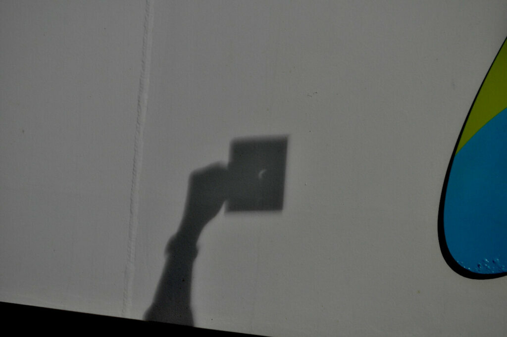 The Pinhole Projection method as described in the story links is a safe and effective way to see and photograph the eclipse. You DO NOT LOOK THROUGH the pinhole as you face AWAY from the Sun.