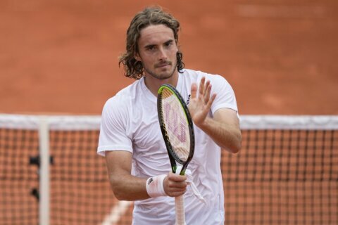 The Latest: Tsitsipas rallies past Isner at French Open