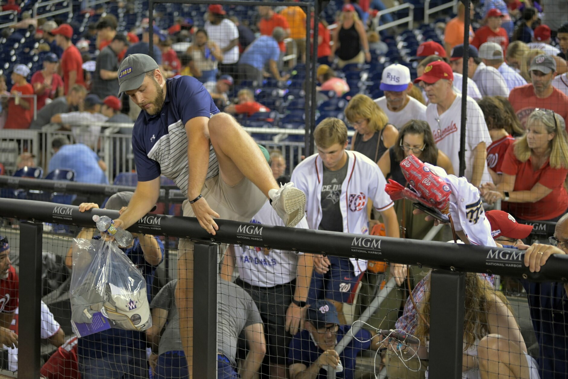 Fans pour out onto the field after hearing gunfire from outside the stadium, during a baseball game between the San Diego Padres and the Washington Nationals at Nationals Park in Washington on Saturday, July 17, 2021. (John McDonnell/The Washington Post via AP)