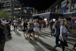 Spectators leave the stadium after an incident near the ballpark during the sixth inning of a baseball game between the Washington Nationals and the San Diego Padres, Saturday, July 17, 2021, in Washington. (AP Photo/Nick Wass)