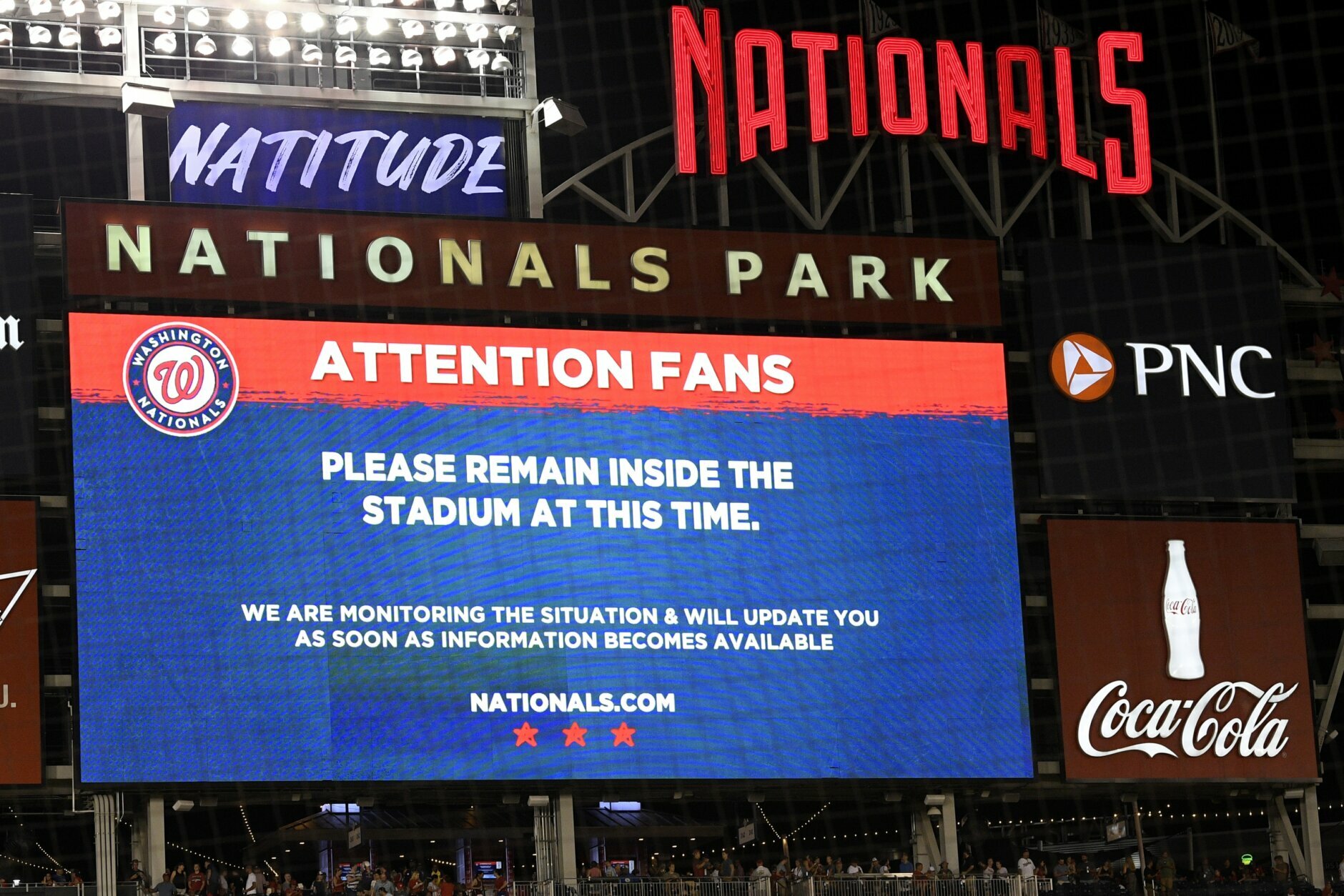 The scoreboard displays a message to fans during a stoppage in play due to an incident near the ballpark in the sixth inning of a baseball game between the Washington Nationals and the San Diego Padres, Saturday, July 17, 2021, in Washington. (AP Photo/Nick Wass)