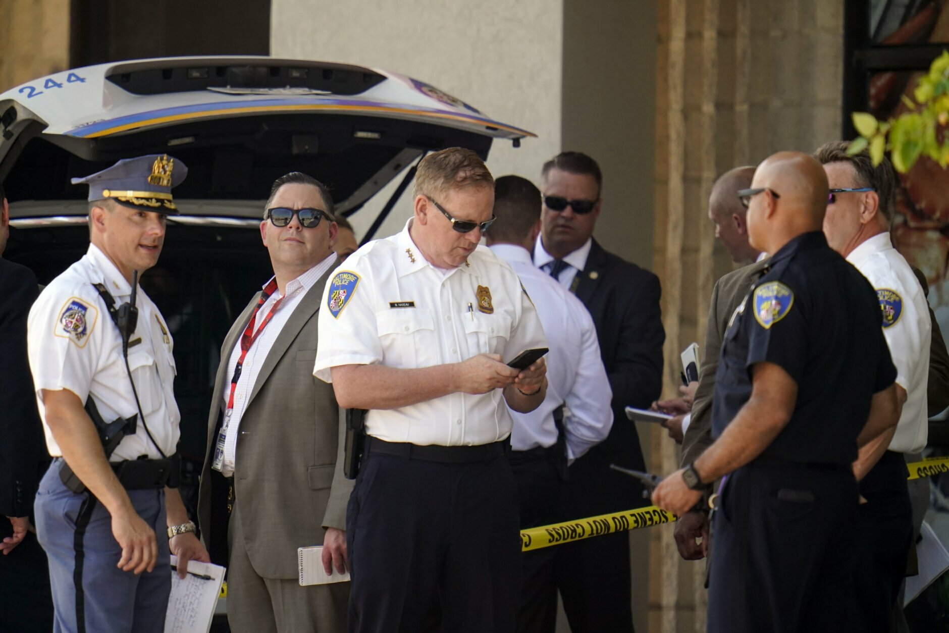 <p>Law enforcement officials gather near a mall parking area where two Baltimore city police officers were shot and a suspect was killed as a U.S. Marshals’ task force served a warrant, Tuesday, July 13, 2021, in Baltimore, Md. The police officers were taken to the University of Maryland Medical Center with injuries that aren’t thought to be life-threatening, county police spokeswoman Joy Stewart said.(AP Photo/Julio Cortez)</p>
