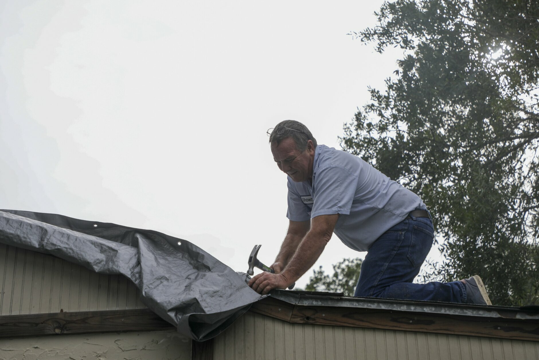 Shawn Frazier, 61, reinforces tarps over his Tampa home's roof ahead of Tropical Storm Elsa on Tuesday, July 6, 2021. Frazier said there was some leaking he caught during a recent rainy day. (Ivy Ceballo/Tampa Bay Times via AP)