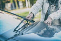 Woman's hand picking up windscreen wiper