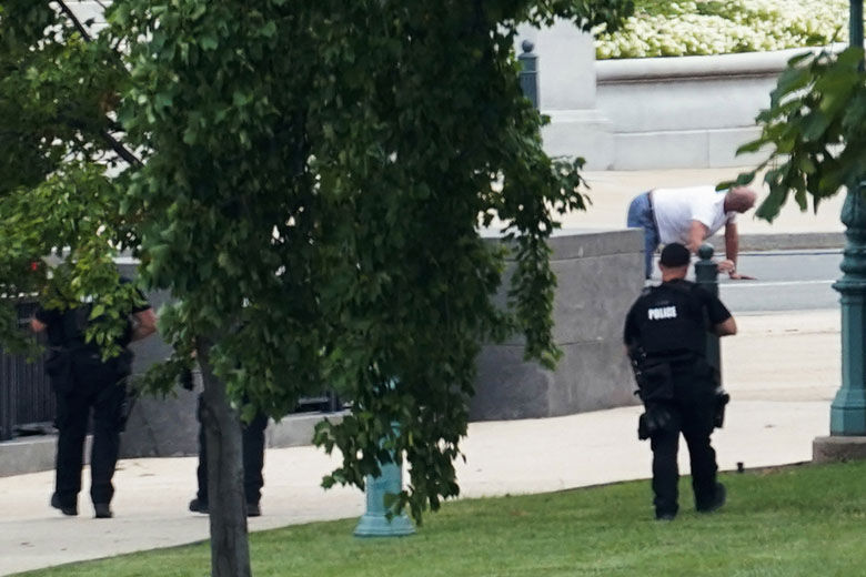 A person is apprehended after being in a pickup truck parked on the sidewalk in front of the Library of Congress' Thomas Jefferson Building, as seen from a window of the U.S. Capitol, Thursday, Aug. 19, 2021, in Washington. Officials evacuated a number of buildings around the Capitol and sent snipers to the area after officers saw a man holding what looked like a detonator inside the pickup, which had no license plates. The man was identified as Floyd Ray Roseberry, 49, of Grover, North Carolina, according to two people briefed on the matter. (AP Photo/Alex Brandon)