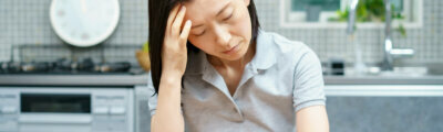 Asian middle-aged woman suffering from headache in the room