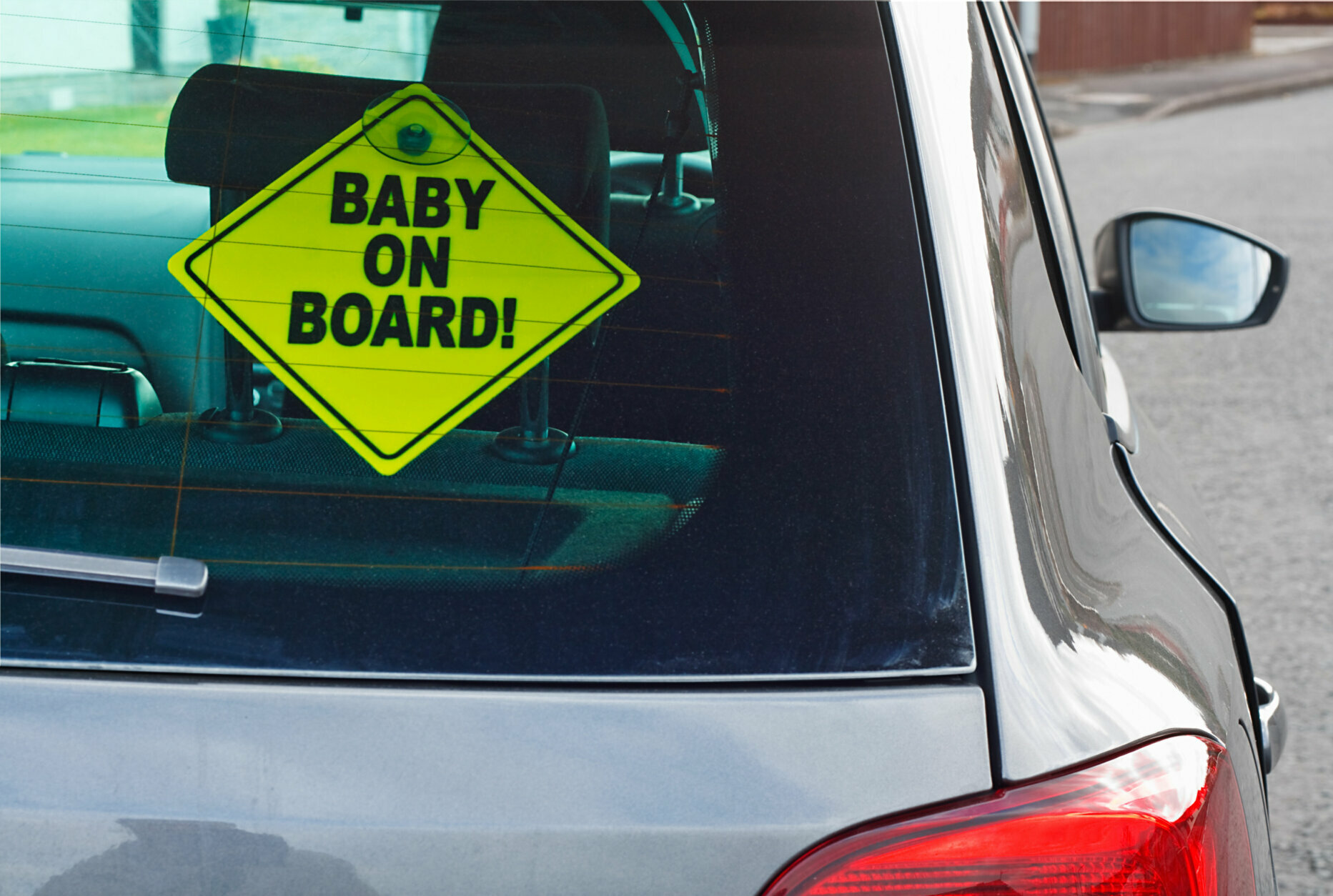 Baby on board warning sign in the back window of a car to advise cars behind of the presence of a toddler