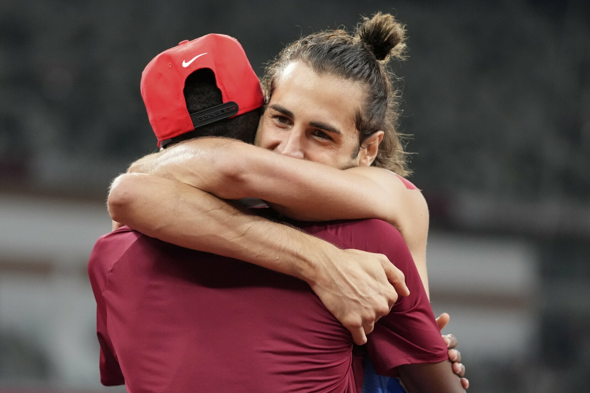 FILE - In this Aug. 1, 2021, file photo, Gianmarco Tamberi, of Italy, embraces fellow gold medalist Mutaz Barshim, of Qatar, after the final of the men's high jump at the 2020 Summer Olympics in Tokyo. In an extraordinary Olympic Games where mental health has been front and center, acts of kindness are everywhere. The world’s most competitive athletes have been captured showing gentleness and warmth to one another — celebrating, pep-talking, wiping away each another’s tears of disappointment.  (AP Photo/Matthias Schrader, File)