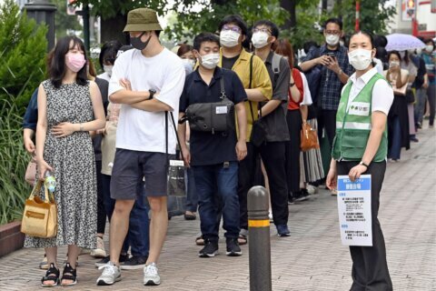 The Latest: Japan aims for full vaccinations by this fall