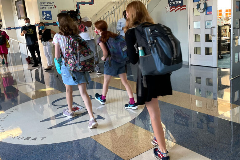 Students with backpacks head into George Washington Middle School for classes in Alexandria on Aug. 24, 2021. (WTOP/Neal Augenstein)