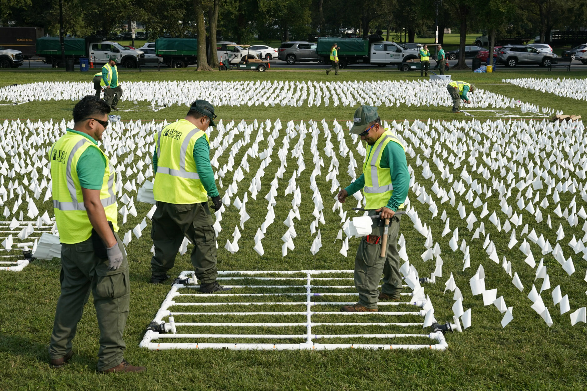 Workers plant white flags as part of artist Suzanne Brennan Firstenberg's temporary art installation, "In America: Remember," in remembrance of Americans who have died of COVID-19, on the National Mall in Washington, Tuesday, Sept. 14, 2021. The installation will consist of more than 630,000 flags when completed. (AP Photo/Patrick Semansky)