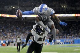Detroit Lions running back D'Andre Swift (32) tries to jump over the tackle of Baltimore Ravens cornerback Brandon Stephens (21) in the second half of an NFL football game in Detroit, Sunday, Sept. 26, 2021. (AP Photo/Tony Ding)