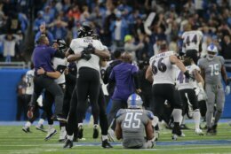 Baltimore Ravens players celebrate a Justin Tucker 66-yard field goal as Detroit Lions linebacker Romeo Okwara (95) sits on the field in the second half of an NFL football game against the Detroit Lions in Detroit, Sunday, Sept. 26, 2021. Baltimore won 19-17. (AP Photo/Tony Ding)