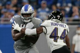 Detroit Lions tight end Darren Fells (80) tries to avoid Baltimore Ravens cornerback Marlon Humphrey (44) in the first half of an NFL football game in Detroit, Sunday, Sept. 26, 2021. (AP Photo/Tony Ding)