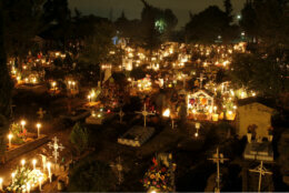 Candles illuminate grave sites at the San Gregorio cemetery during the Dia de los Muertos or Day of the Dead holiday on the outskirts of Mexico City, Tuesday Nov. 1, 2011.  A tradition that coincides with All Saints Day and All Souls Day on Nov. 1 and 2.,  families take picnics to the cemeteries and decorate the graves of departed relatives with marigolds, candles and sugar skulls. (AP Photo/Marco Ugarte)