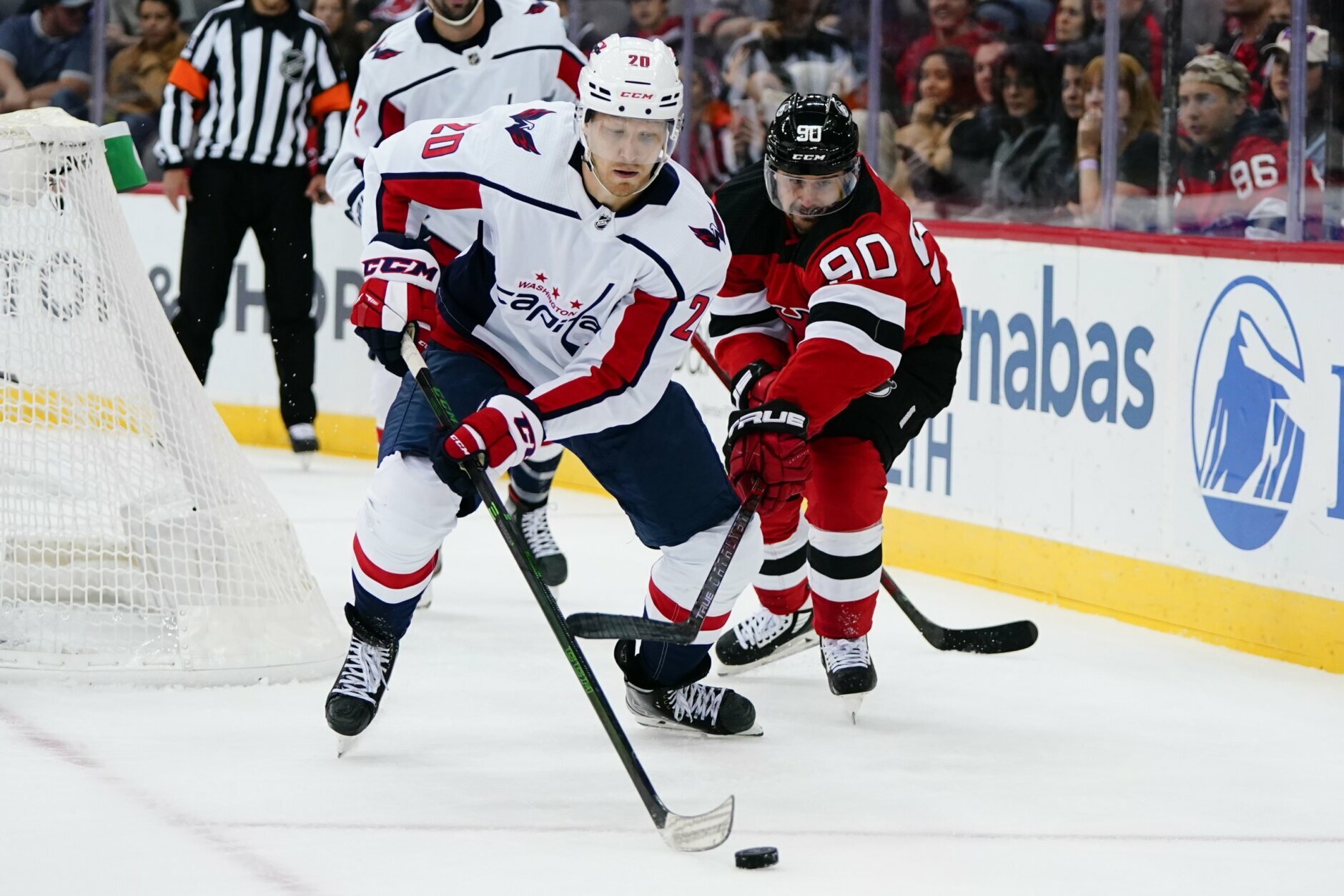 Washington Capitals' Lars Eller (20) and New Jersey Devils' Tomas Tatar (90) reach for the puck during the first period of an NHL hockey game Thursday, Oct. 21, 2021, in Newark, N.J. (AP Photo/Frank Franklin II)