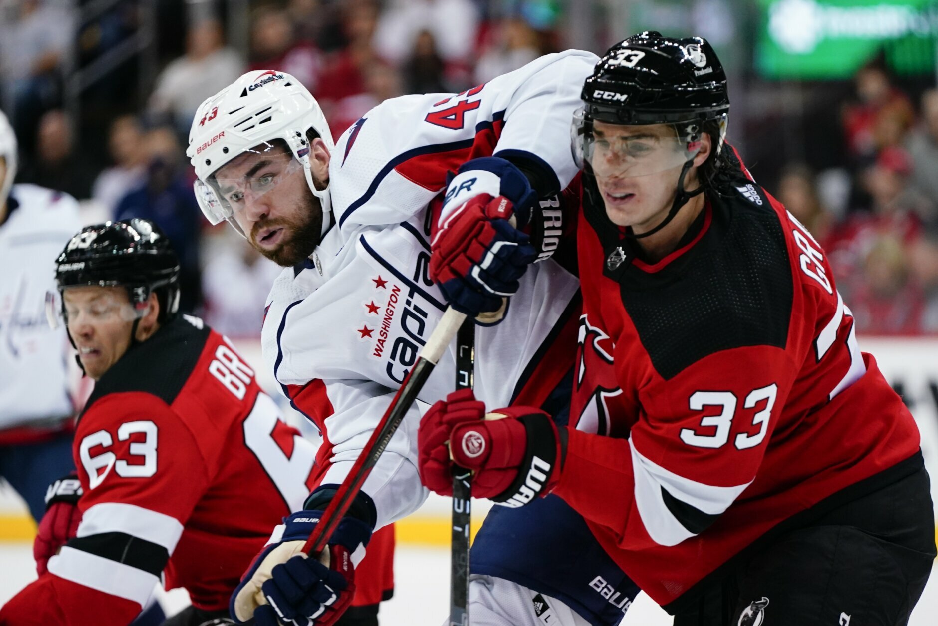 Washington Capitals' Tom Wilson (43) jostles for position with New Jersey Devils' Ryan Graves (33) during the second period of an NHL hockey game Thursday, Oct. 21, 2021, in Newark, N.J. (AP Photo/Frank Franklin II)