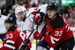 Washington Capitals' Tom Wilson (43) jostles for position with New Jersey Devils' Ryan Graves (33) during the second period of an NHL hockey game Thursday, Oct. 21, 2021, in Newark, N.J. (AP Photo/Frank Franklin II)