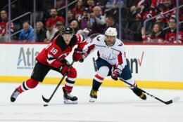 New Jersey Devils' Dawson Mercer (18) fights for control of the puck with Washington Capitals' Alex Ovechkin (8) during the first period of an NHL hockey game Thursday, Oct. 21, 2021, in Newark, N.J. (AP Photo/Frank Franklin II)