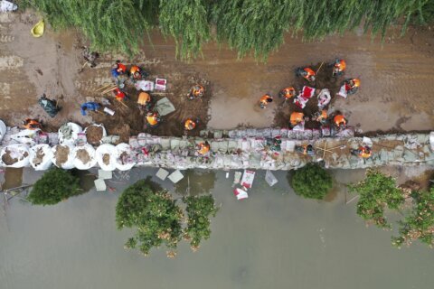 Flooding sends bus into river in China; 120,000 evacuated