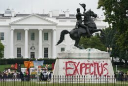 The words "Expect Us" are painted on the base of the equestrian statue of President Andrew Jackson in Lafayette Park as protesters gather to call on the Biden administration to do more to combat climate change and ban fossil fuels outside the White House in Washington, Tuesday, Oct. 12, 2021. The words are part of the phrase "Respect Us, or Expect Us" which indigenous women have been using while protesting oil company Enbridge's Line 3 pipeline through Minnesota. (AP Photo/Patrick Semansky)