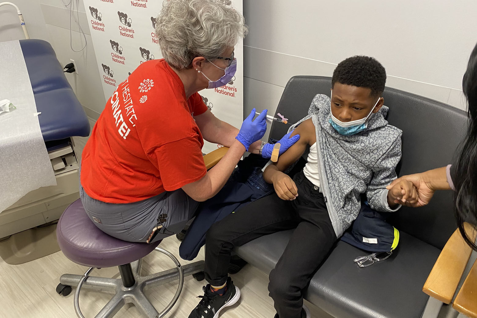 Aiden Lewis, 10, rolled up his sleeve for one of the first shots in D.C. (WTOP/John Aaron)