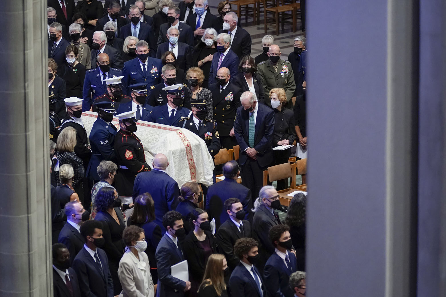 President Joe Biden watches as the casket of former Secretary of State Colin Powell is carried during a funeral service at the Washington National Cathedral, in Washington, Friday, Nov. 5, 2021. (AP Photo/Evan Vucci)
