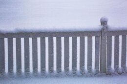 Beautiful snow winter background. White wooden fence covered with snow.