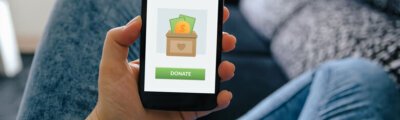 Girl holding smart phone with donation concept on screen