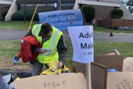 <p>Volunteers distribute coats Friday outside Our Lady of Perpetual Help Church in Southeast D.C. (WTOP/Kate Ryan)</p>
