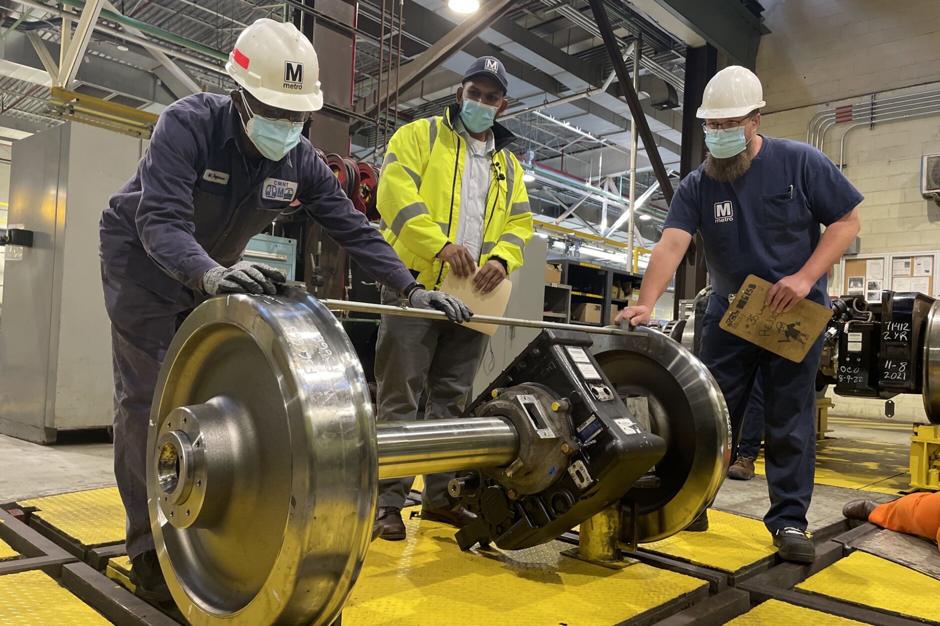 <p>A Metro crew demonstrates how a wheel set assembly for 7000-series trains is measured. This wheel set was removed from the train for illustrative purposes.</p>
