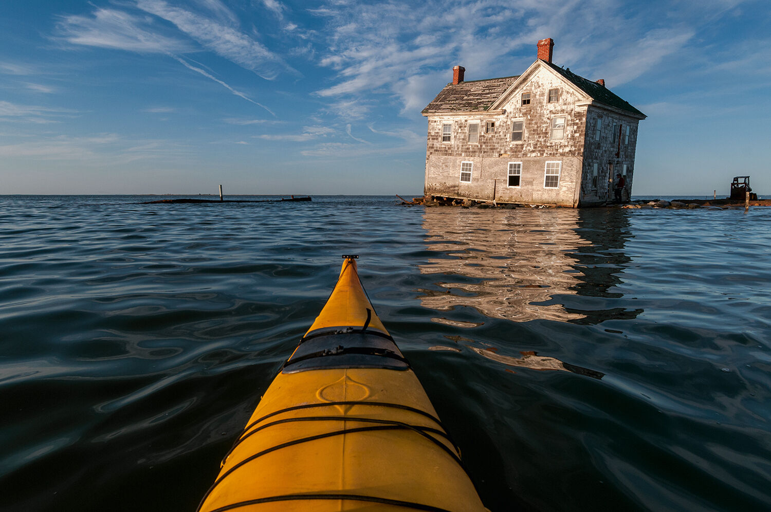 <p>One of his favorite images from the new book is the image of a dilapidated house on Holland Island. He took the photo in 2010 from a kayak.</p>
<p>&#8220;I was very low to the water. So I was able to capture the reflection of the house kind of like an abstract reflection, kind of like melting into the water. So it&#8217;s kind of symbolic,&#8221; he said, of how these communities are really on the edge.</p>
<p>Six months after he took that shot, the house was gone. It had collapsed into the waters of the bay.</p>
