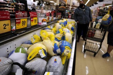 People shop for frozen turkeys for Thanksgiving dinner at a grocery store in Mount Prospect, Ill., Wednesday, Nov. 17, 2021. (AP Photo/Nam Y. Huh)