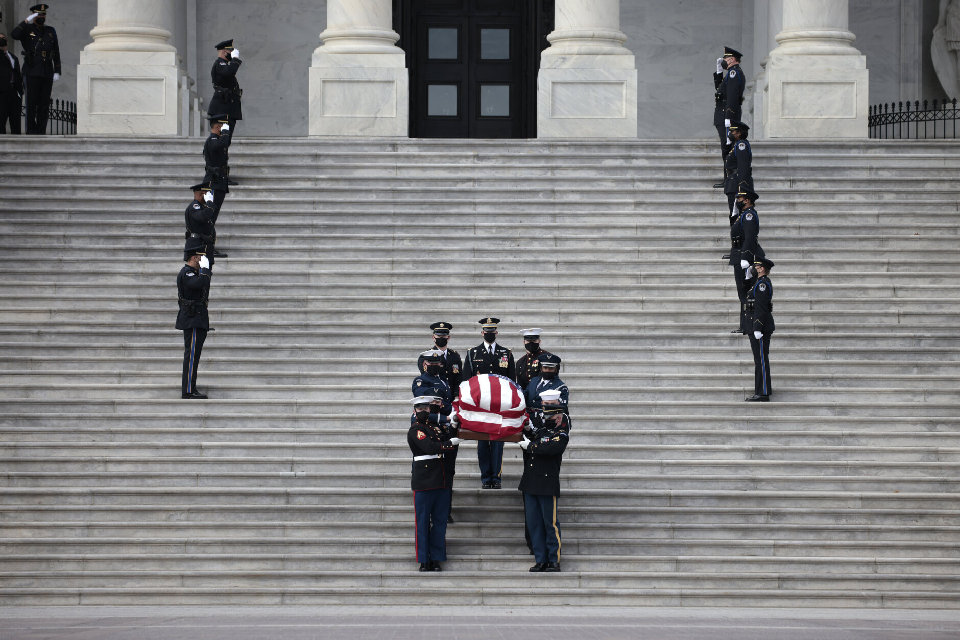 A military honor guard carries the flag-draped casket of former Sen. Bob Dole of Kansas, from the U.S. Capitol in Washington, Friday, Dec. 10, 2021, after lying in state. (Anna Moneymaker/Pool via AP)