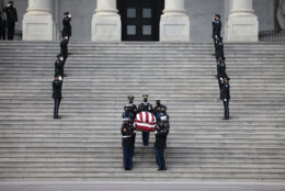 A military honor guard carries the flag-draped casket of former Sen. Bob Dole of Kansas, from the U.S. Capitol in Washington, Friday, Dec. 10, 2021, after lying in state. (Anna Moneymaker/Pool via AP)