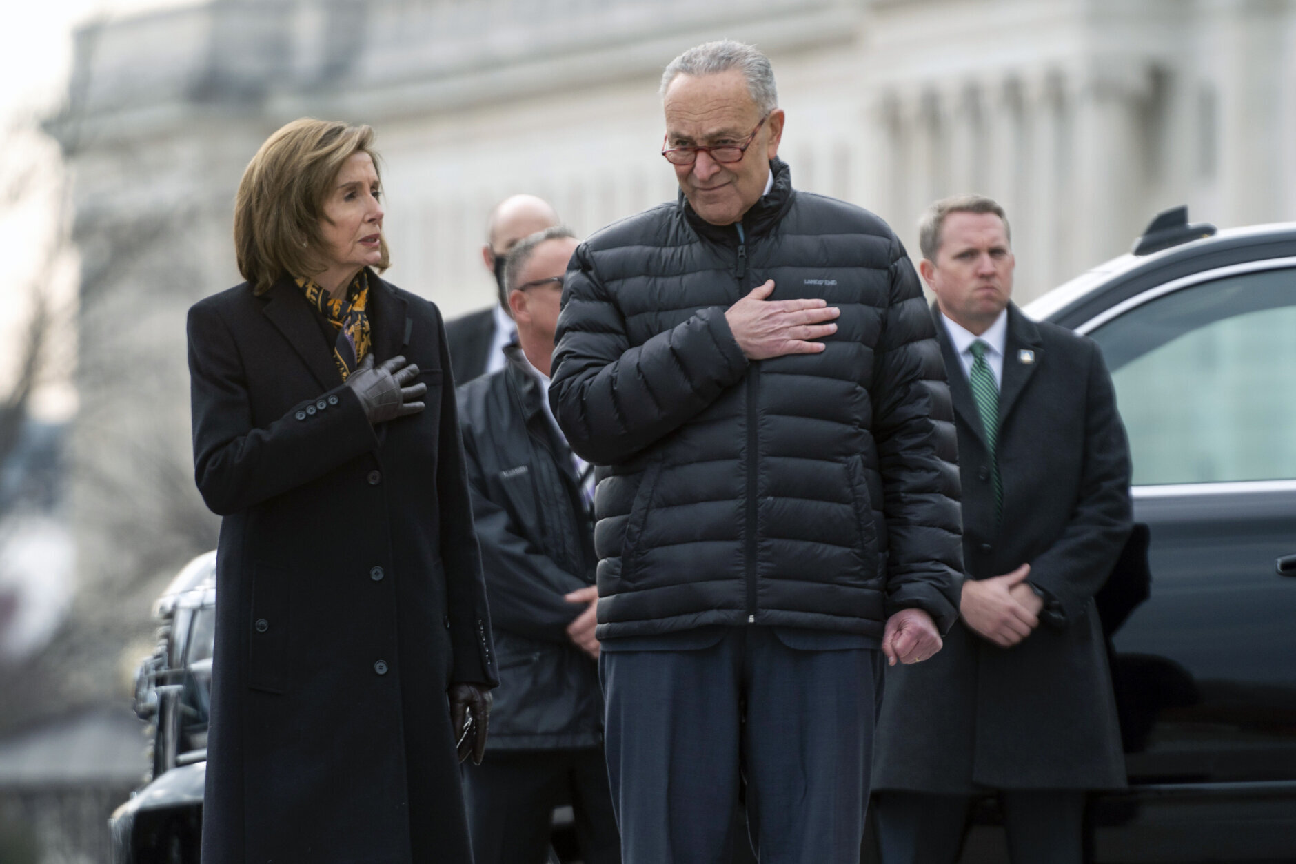 House Speaker Nancy Pelosi of Calif., and Senate Majority Leader Chuck Schumer of N.Y., watch as a military honor guard carries the flag-draped casket of former Sen. Bob Dole from the U.S. Capitol in Washington, Friday, Dec. 10, 2021, where he had lied in state on Thursday and over night.  (Greg Nash/Pool via AP)