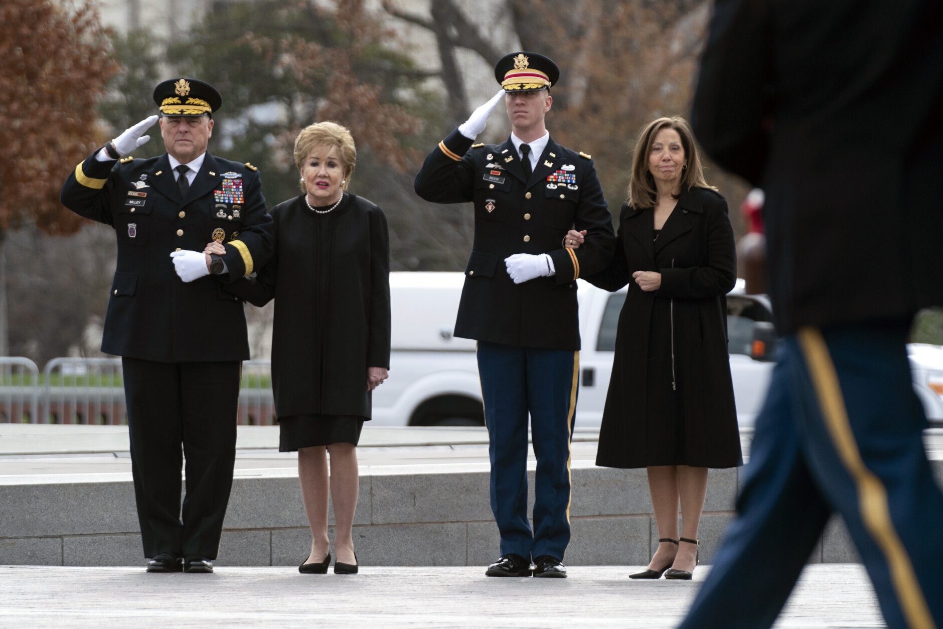 Former Sen. Elizabeth Dole, second left, accompanied with Joint Chiefs of Staff Chairman Marine General Mark Milley and Robin Dole, watch a military honor guard carry the flag-draped casket of former Sen. Bob Dole of Kansas, from the Capitol in Washington, Friday, Dec. 10, 2021, after lying in state. (Greg Nash/Pool via AP)