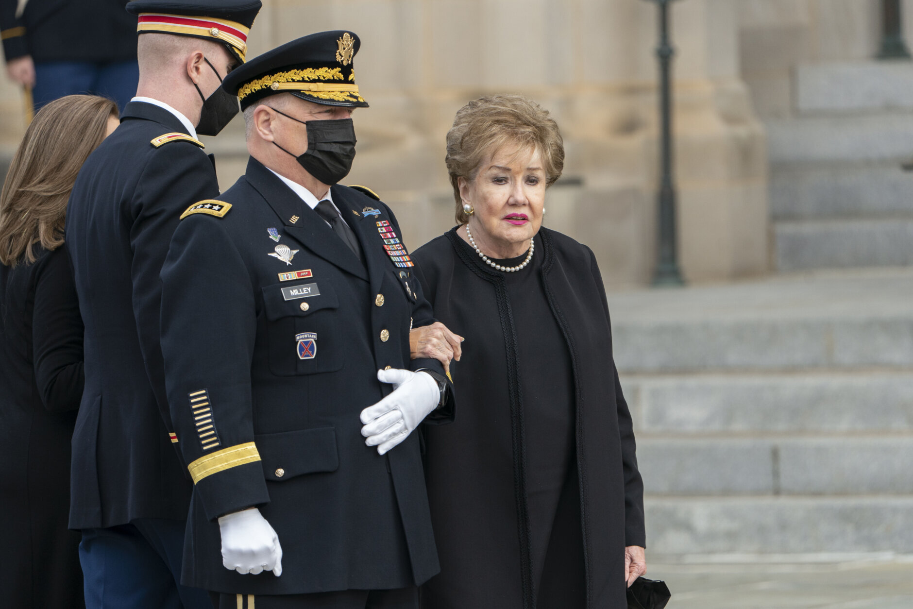 Former Sen. Elizabeth Dole, right, wife of former Sen. Bob Dole of Kansas, accompanied by Chairman of the Joint Chiefs Mark Milley, left, watch as the casket of former Sen. Bob Dole, is carried into the Washington National Cathedral for a funeral service, Friday, Dec. 10, 2021, in Washington. (AP Photo/Manuel Balce Ceneta)