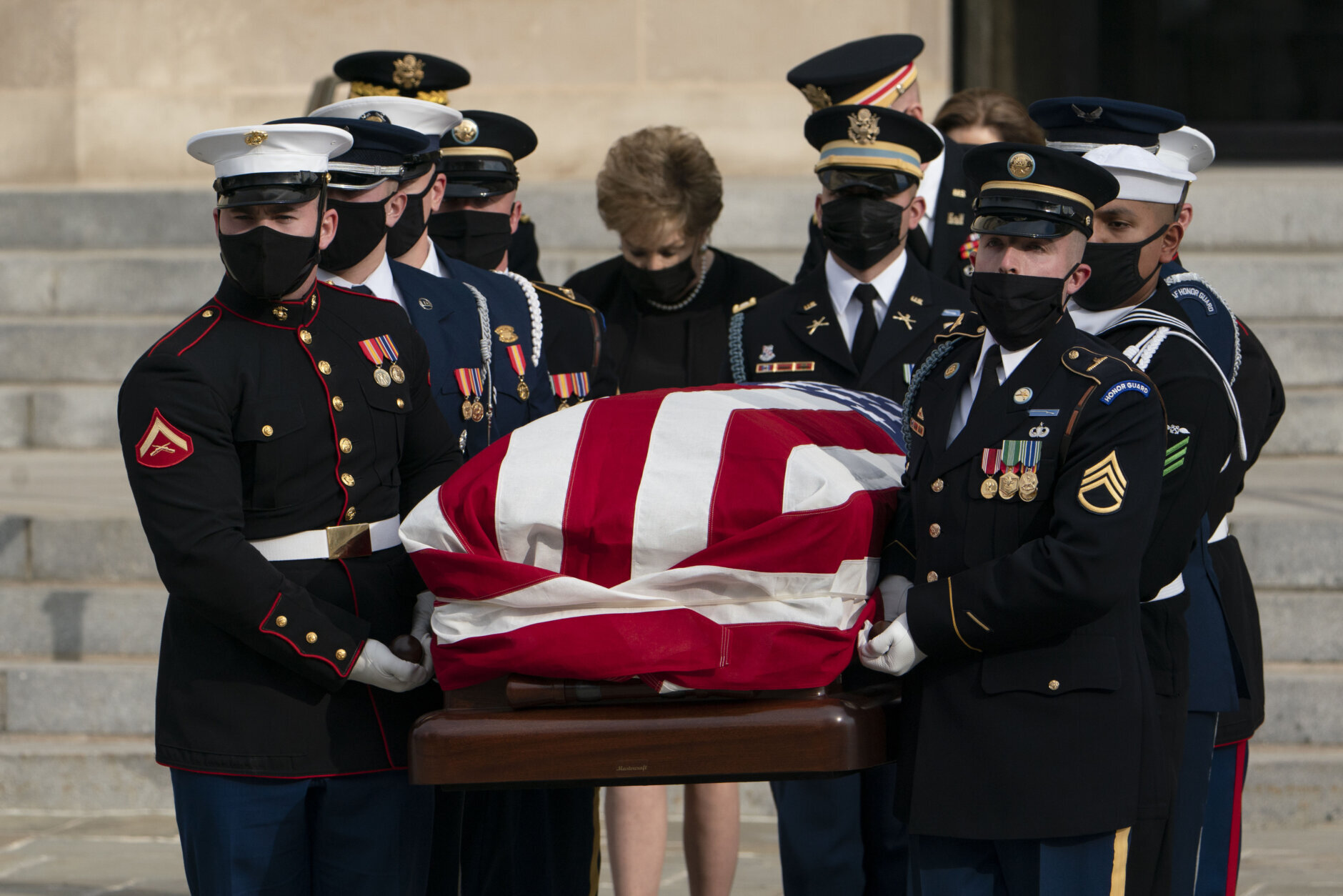 Former Sen. Elizabeth Dole, center, walks behind the flag-draped casket of her husband, former Sen. Bob Dole of Kansas, as it is carried from the Washington National Cathedral following a funeral service, Friday, Dec. 10, 2021, in Washington. (AP Photo/Manuel Balce Ceneta)